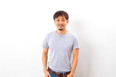 Beyaz arka planda sakallı ve tişörtlü yakışıklı bir adam.