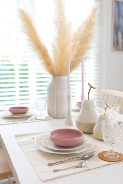 Evdeki yemek masasında beyaz ve mor tabak..