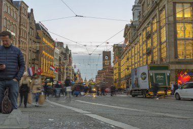 Amsterdam, Hollanda - 29 Kasım 2019: Amsterdam, Hollanda 'da Dam Meydanı' nda tramvayla yürüyen kimliği belirsiz kişiler