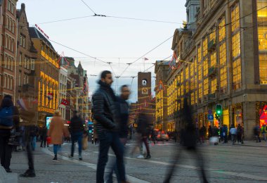 Amsterdam, Hollanda - 29 Kasım 2019: Amsterdam, Hollanda 'da Dam Meydanı' nda tramvayla yürüyen kimliği belirsiz kişiler