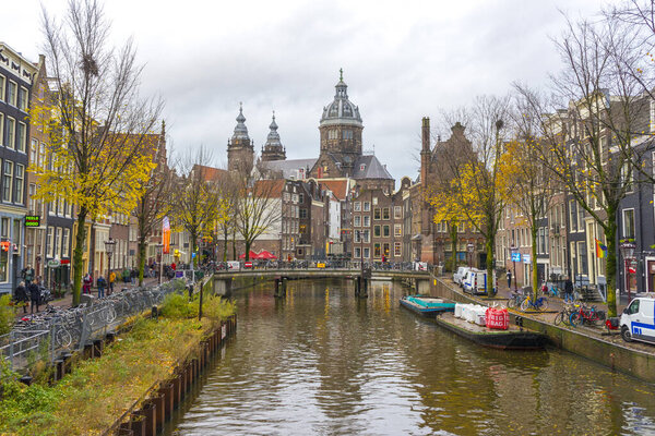 Amsterdam, Netherlands - Nov 27, 2019 : View of houses and Boats on Amsterdam Canal at twilight in Amsterdam, Netherlands on Nov 27, 2019.