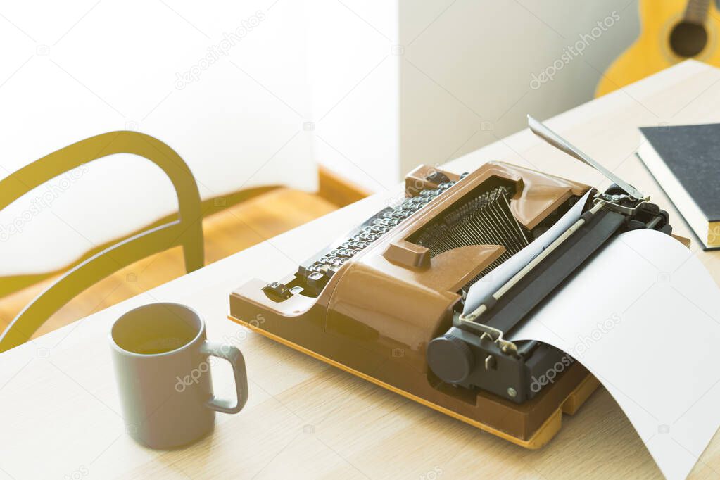 Stylish hipster work space, retro typewriter and coffee cup on office desk. Writers home office.