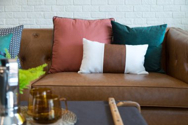 Deri bir kanepede renkli yastıklar 