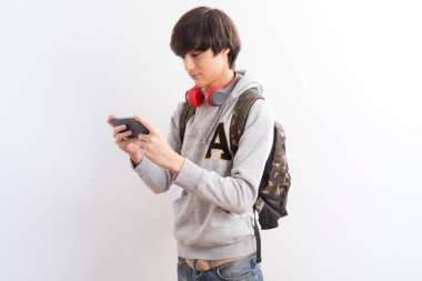 Beyaz arka planda cep telefonu ve kulaklığı olan genç bir adam.