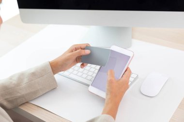 Akıllı telefon ve kart tutan kadınların yakın plan fotoğrafları.