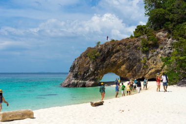 Satun, Tayland - 7. 2021: Birçok turist, 7. Mar 2021 'de Tayland' ın başkenti Satun 'da Koh Lipe yakınlarındaki Koh Khai' de beyaz kumlu plajın ve taş kemerin keyfini çıkarıyor..