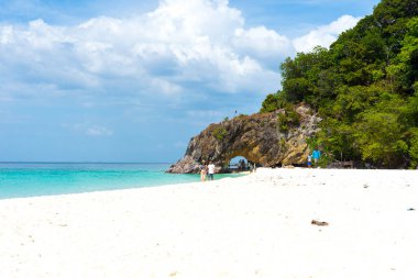 Satun, Tayland - 7. 2021: Birçok turist, 7. Mar 2021 'de Tayland' ın başkenti Satun 'da Koh Lipe yakınlarındaki Koh Khai' de beyaz kumlu plajın ve taş kemerin keyfini çıkarıyor..