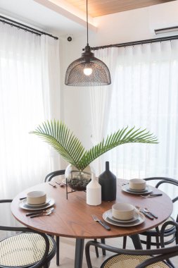 modern oturma odası içinde lamba, masa ve sandalyeler var.