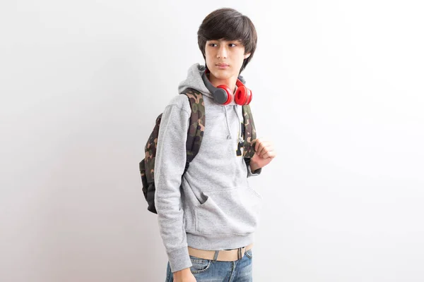 年轻男孩 背着白色背景的背包和耳机 — 图库照片