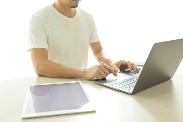 男子使用笔记本电脑和白底平板电脑 — 图库照片