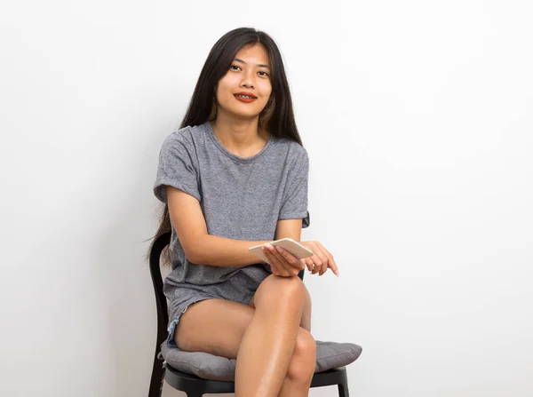 Junge Frau Sitzt Auf Stuhl Und Benutzt Smartphone — Stockfoto