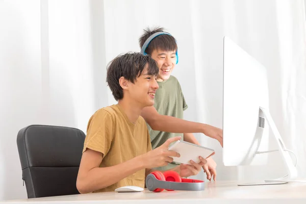 Dwóch Nastoletnich Chłopców Słuchawką Przy Użyciu Komputerów Gry Online Domu — Zdjęcie stockowe