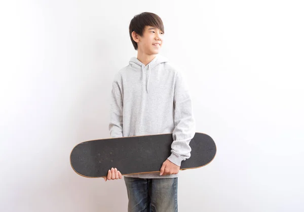 Азиатский Подросток Держит Скейтбординг Изолирован Белом Фоне — стоковое фото