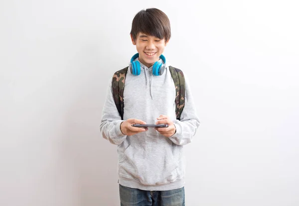 Teenager Boy Backpack Headphones Holding Smartphone Looking Camera Isolated White — 스톡 사진