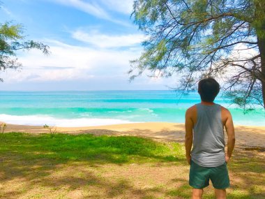 Genç adam denize bakıyor.