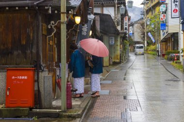 Nagano, Japonya - 16 Aralık 2019: Japonya 'nın Nagano şehrindeki Shibu Onsen şehrinde tarihi ryokan ve sıcak bahar otellerinde yürüyen kimliği belirsiz bir çift
