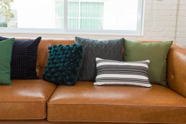 Oturma odasında yastıklı deri kanepe.