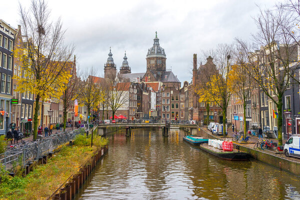 Amsterdam, Netherlands - Nov 27, 2019 : View of houses and Boats on Amsterdam Canal at twilight in Amsterdam, Netherlands on Nov 27, 2019.