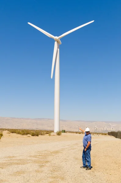 Man pointing to the wind powered generator tower — Stock Photo, Image