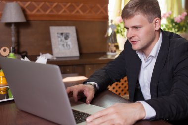 Akıllı telefon ve defter compu kullanarak evden çalışan genç adam