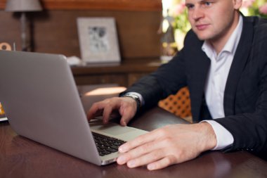 Akıllı telefon ve defter compu kullanarak evden çalışan genç adam