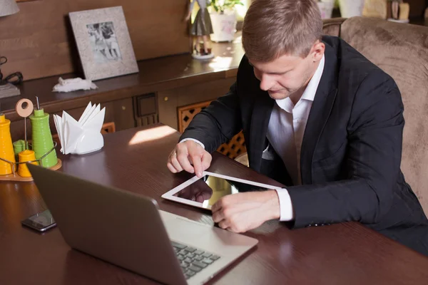 Jovem trabalhando em casa usando telefone inteligente e notebook compu — Fotografia de Stock