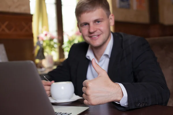 Biznes, technologie. Młody mężczyzna pracujący na laptopie z o kubek — Zdjęcie stockowe