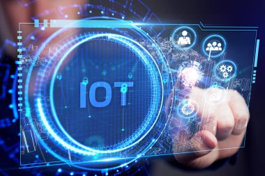 Nesnelerin interneti - IOT konsepti. İşadamı IOT ürünleri ve çözümler sunuyor. Genç işadamı sanal ekranda IoT metin ile soyut çipi seçin. 
