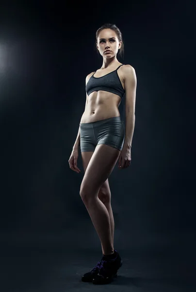 Retrato de esportivo jovem mulher com corpo muscular olhando para cam — Fotografia de Stock