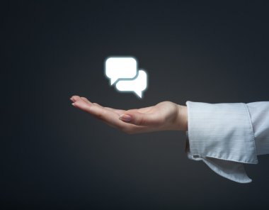 Sohbet işareti simgesi tutan el. İletişim kavramı.