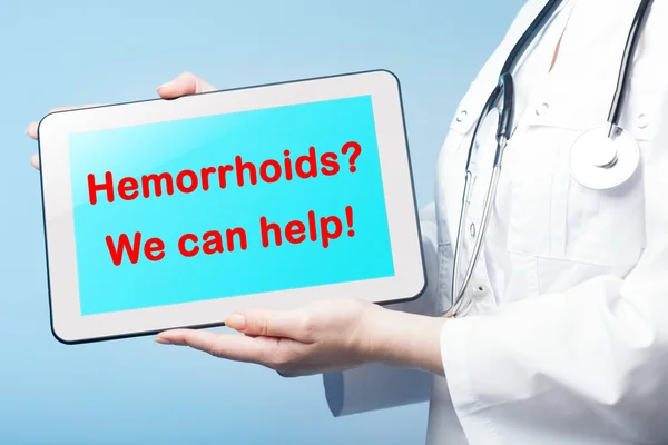 Κοπέλα που κρατά το δισκίο με τη διάγνωση Hemorrhoid στην οθόνη — Φωτογραφία Αρχείου