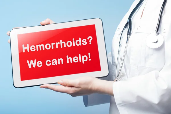 Κοπέλα που κρατά το δισκίο με τη διάγνωση Hemorrhoid στην οθόνη — Φωτογραφία Αρχείου