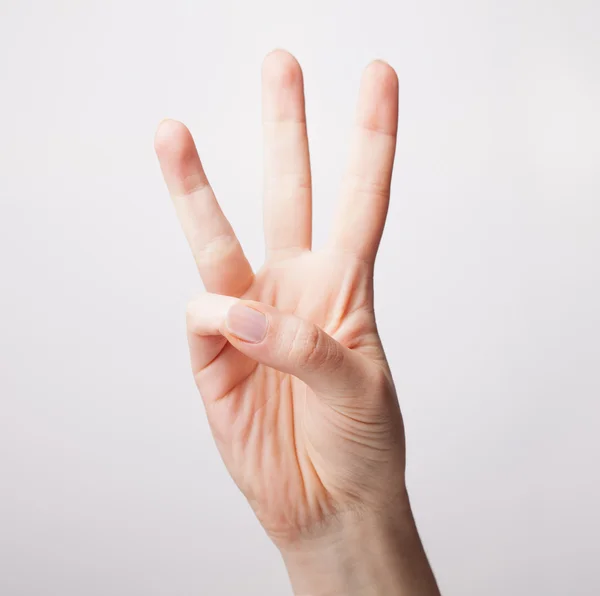 Mão feminina está mostrando três dedos isolados no backgroun branco — Fotografia de Stock