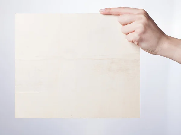 Рука тримає порожній папір ізольовано на білому тлі — стокове фото