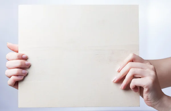 Рука тримає порожній папір ізольовано на білому тлі — стокове фото