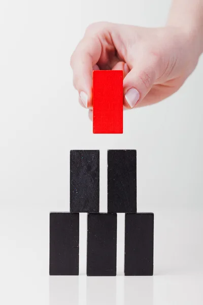 Una mano umana mette un gioco domino. Tutto isolato su sfondo bianco — Foto Stock