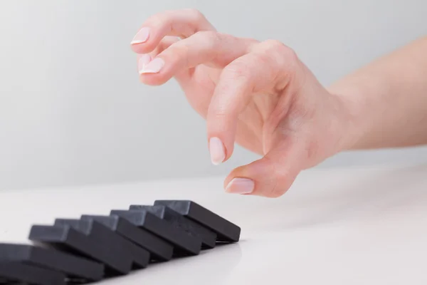 Raden av dominos faller ner efter skjuts av finger — Stockfoto