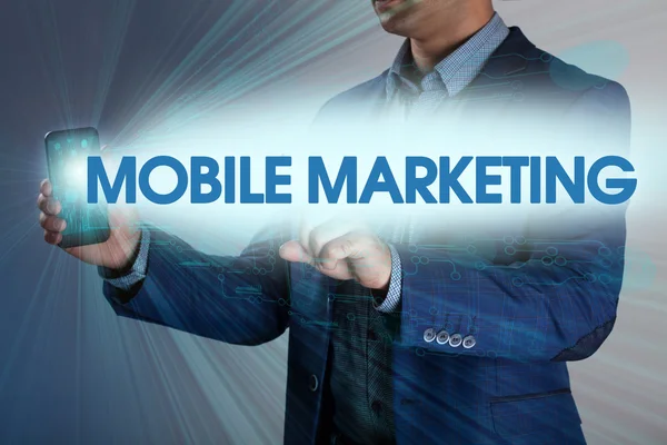 Biznesmen naciska przycisk marketing mobilny na wirtualnych ekranach. — Zdjęcie stockowe