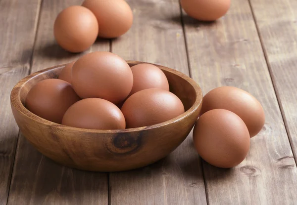 Huevos en un tazón de madera — Foto de Stock