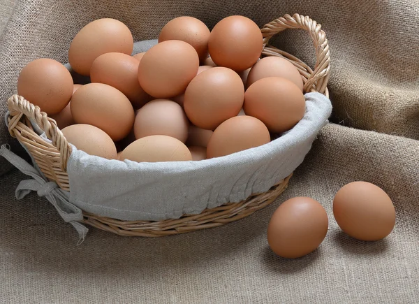 Ovos de galinha em uma cesta em pano de saco — Fotografia de Stock