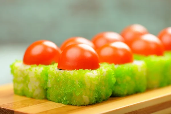 Tasty Japanese fantasy rolls with cherry tomatoes and green cavi