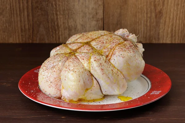 Bondage shibari oiled and spiced raw chicken on red boarder plat — Stock Image Bondage shibari oiled and spiced raw chicken on red boarder plat Royalty Free Stock Images