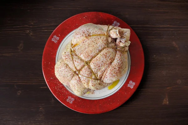 Bondage shibari oiled and spiced raw chicken on red boarder plat — Stock Image Bondage shibari oiled and spiced raw chicken on red boarder plat Stock Photo