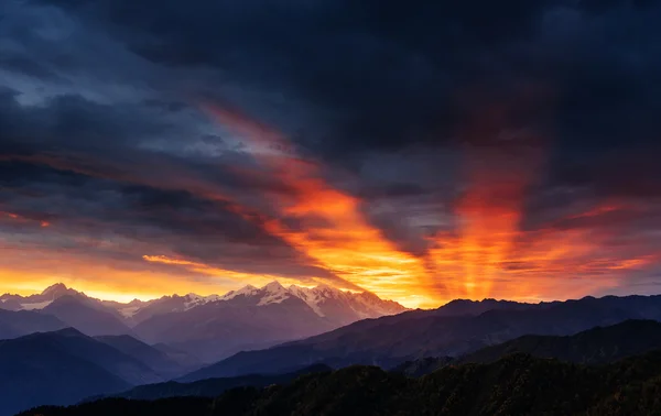 Ηλιοβασίλεμα πάνω από τις χιονισμένες κορυφές των βουνών. — Φωτογραφία Αρχείου
