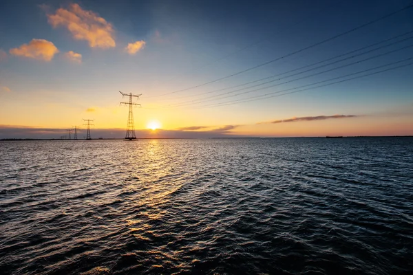 electric line above water during a fantastic sunset.