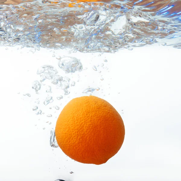 Πορτοκάλι σε σπρέι νερού. Πορτοκαλί με βουτιά σε λευκό φόντο — Φωτογραφία Αρχείου