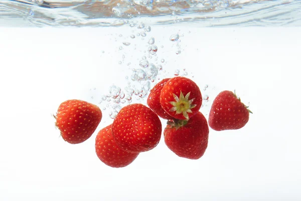 Świeże truskawki spadł do wody z splash — Zdjęcie stockowe