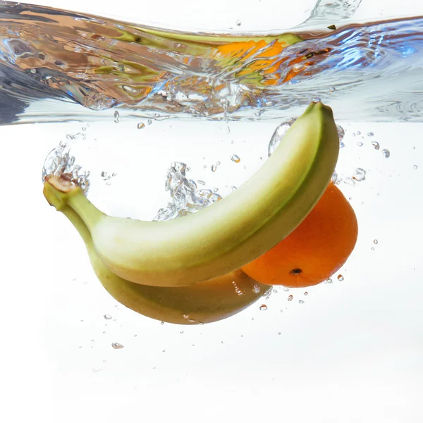 バナナ、オレンジ、白で隔離、水に落ちた — ストック写真