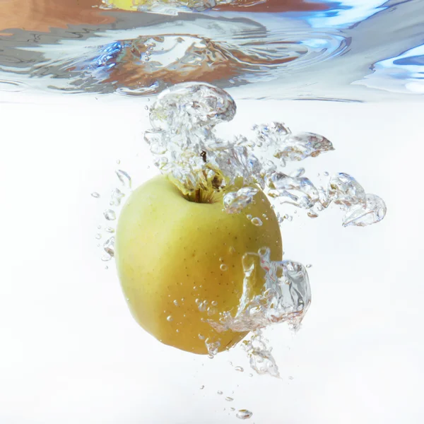 Green apple under water with a trail of transparent bubbles. — Stock Photo, Image