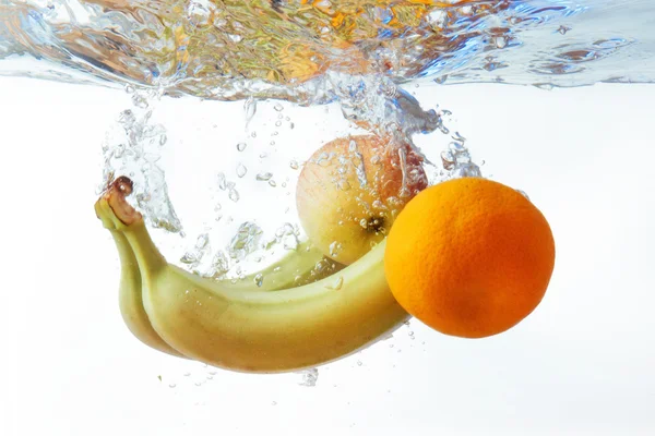 Бананы, апельсины и яблоко упало в воду — стоковое фото